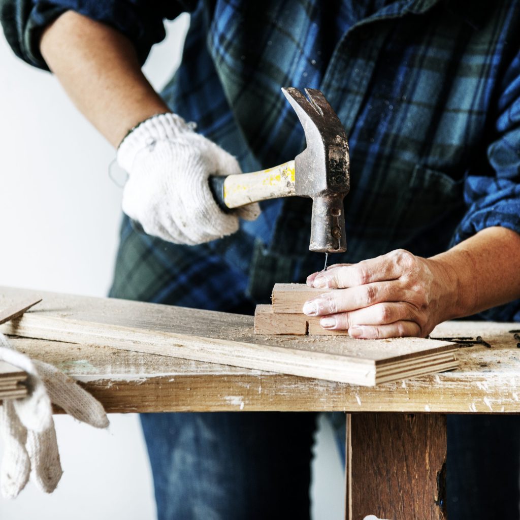 woman-carpenter-using-hammer-pushing-nail-wood-scaled.jpg
